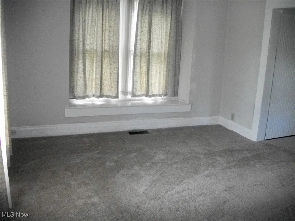 Living room with window seat with neutral carpet.