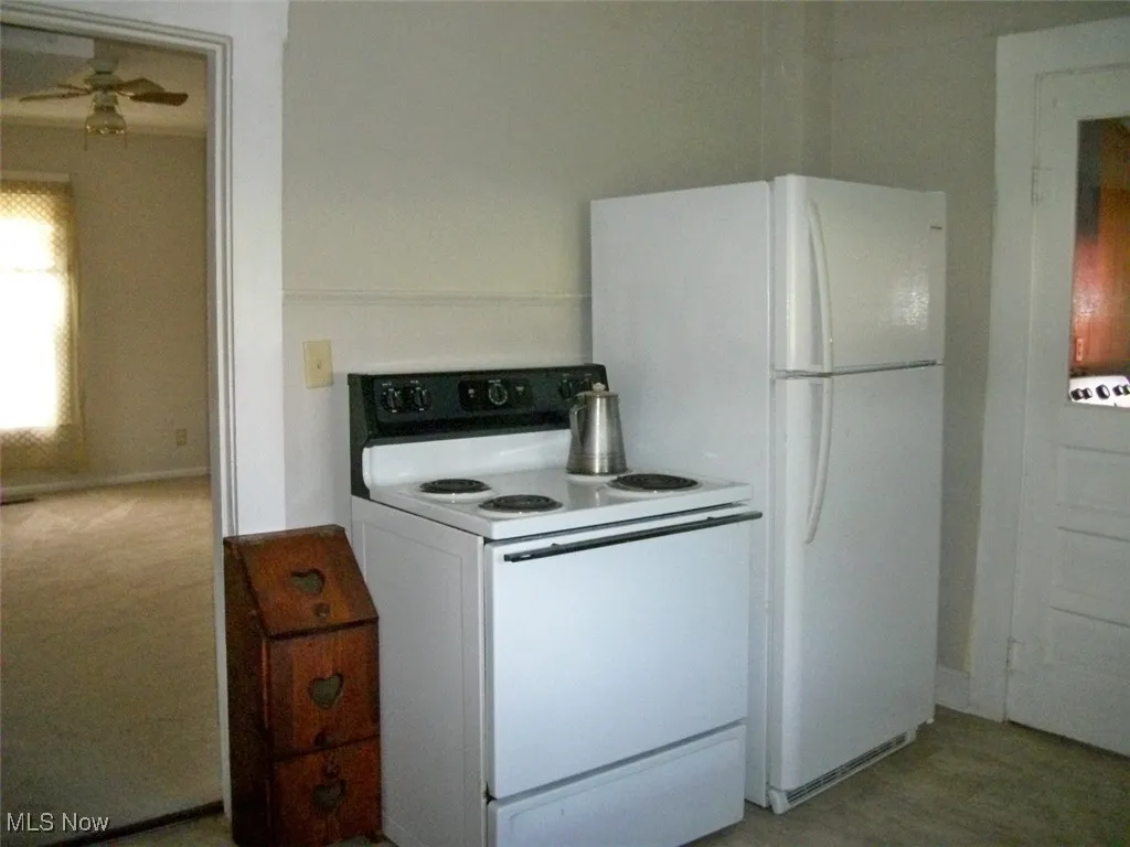 Kitchen featuring white electric range and a ceiling fan