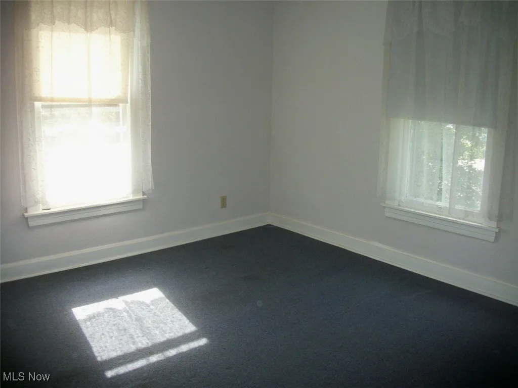  second bedroom featuring baseboards and dark carpet