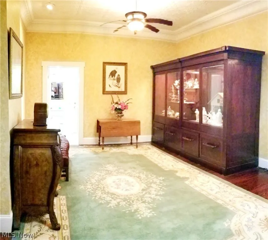 Living area with crown molding and ceiling fan