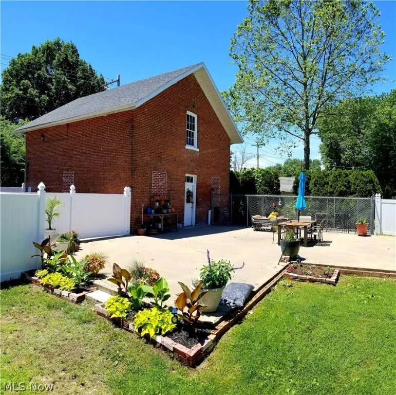 View of property exterior with a patio area and a lawn