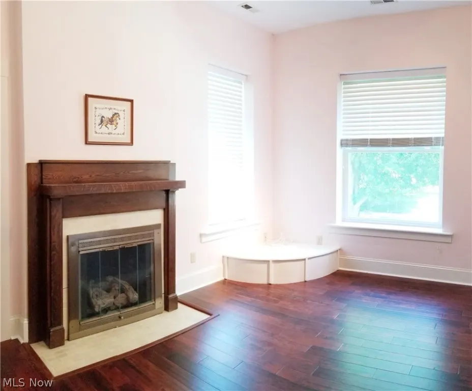 Unfurnished living room featuring dark wood-type flooring