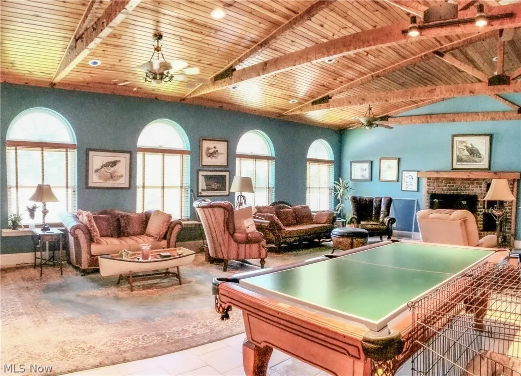 Game room with ceiling fan, a fireplace, light tile floors, and billiards