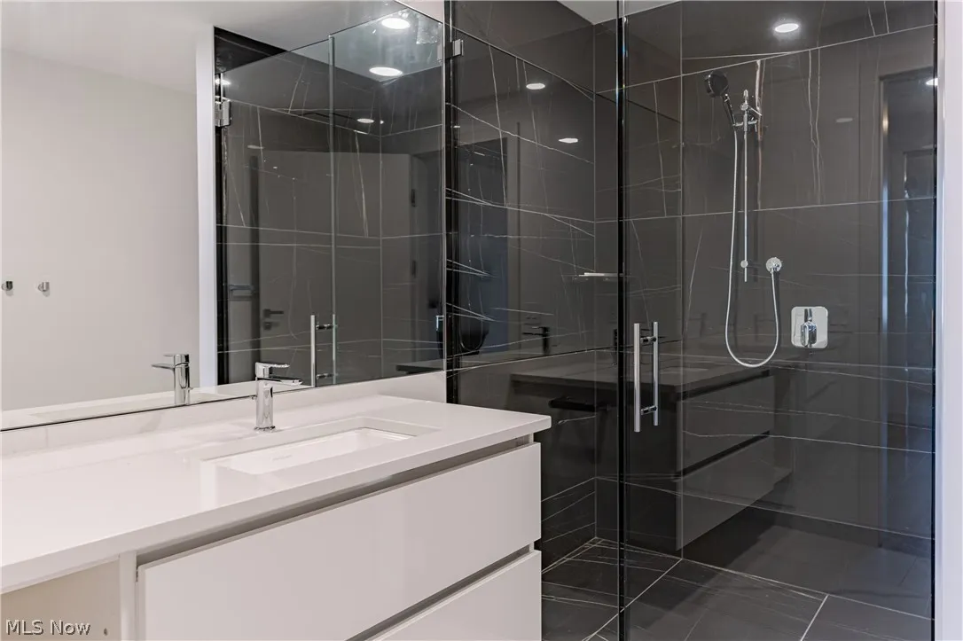 Bathroom featuring vanity and a shower with door