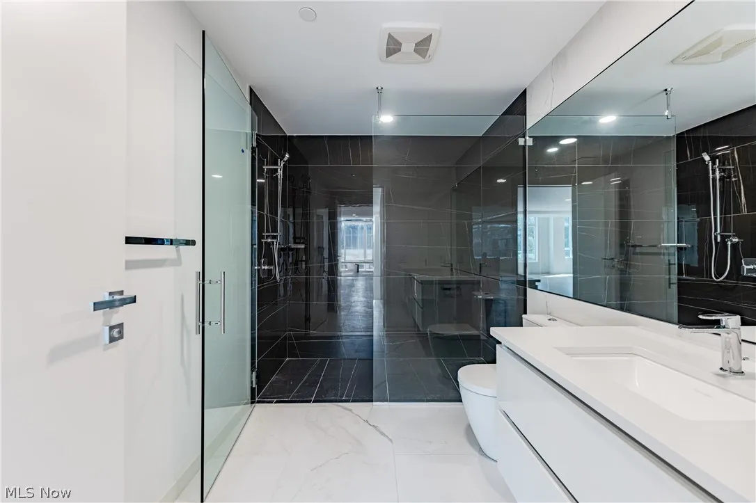 Bathroom with walk in shower, toilet, oversized vanity, and tile flooring