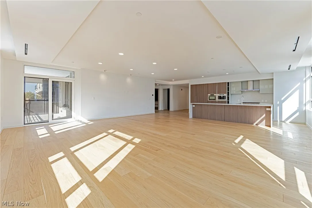 Unfurnished living room with sink and light hardwood / wood-style floors