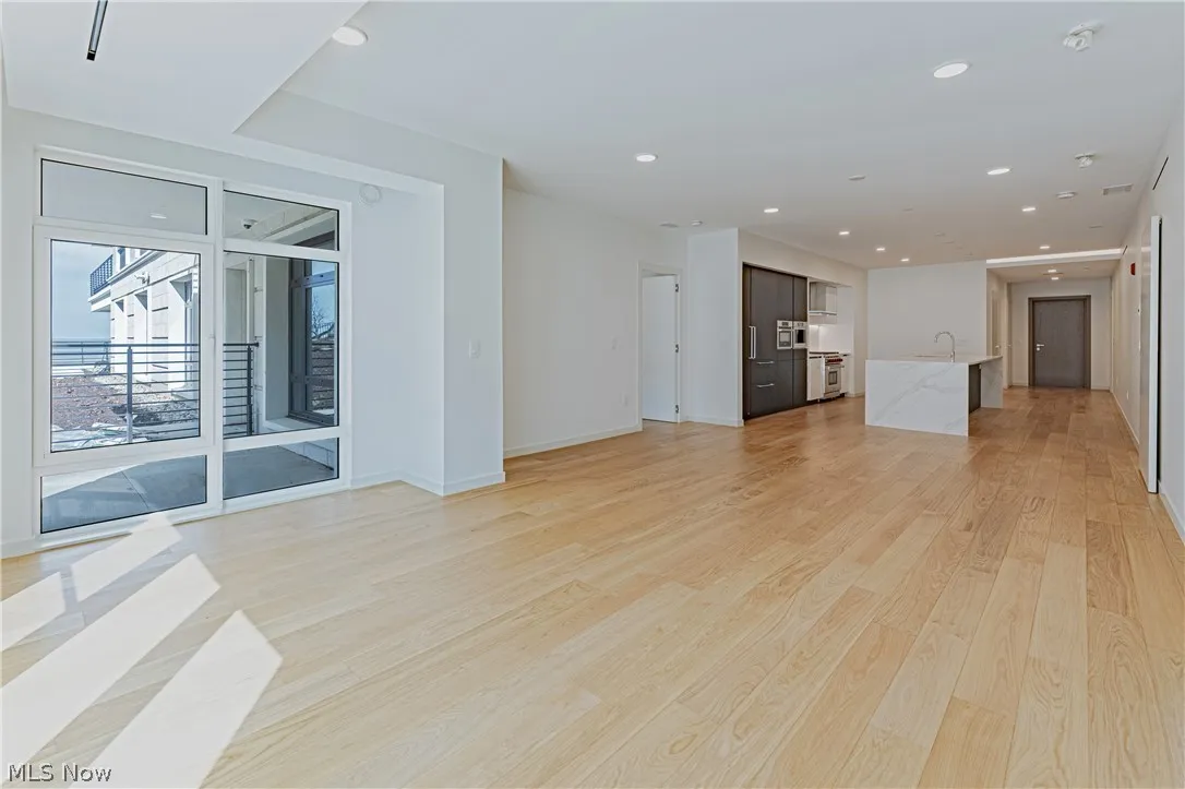 Unfurnished living room with light hardwood / wood-style flooring and sink