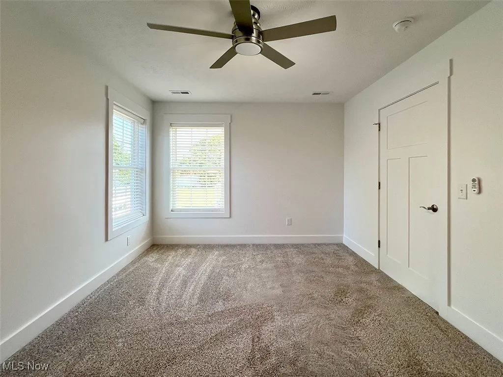 Bedroom with a smoke detector, carpet flooring, and ceiling fan level 2