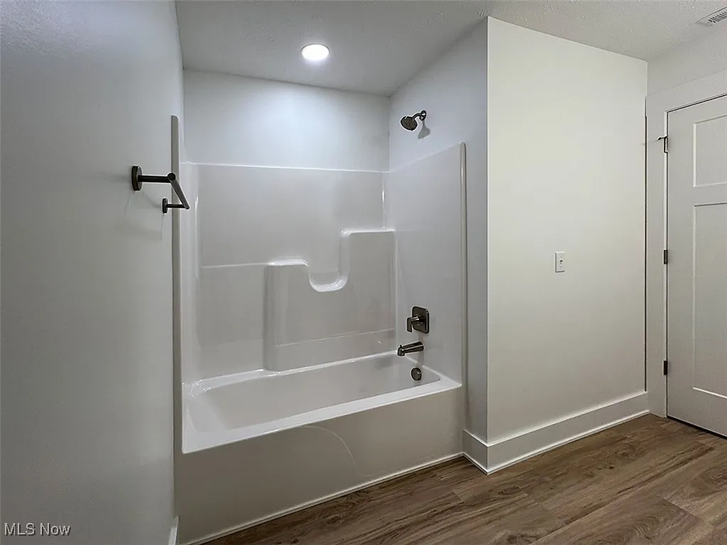 Master bath with wood finished floors, bathing tub / shower combination, and recessed lighting level 2