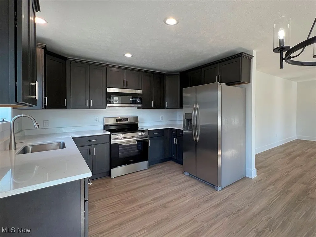 Kitchen featuring stainless steel appliances, light wood-style flooring, recessed lighting, and white quartz countertops