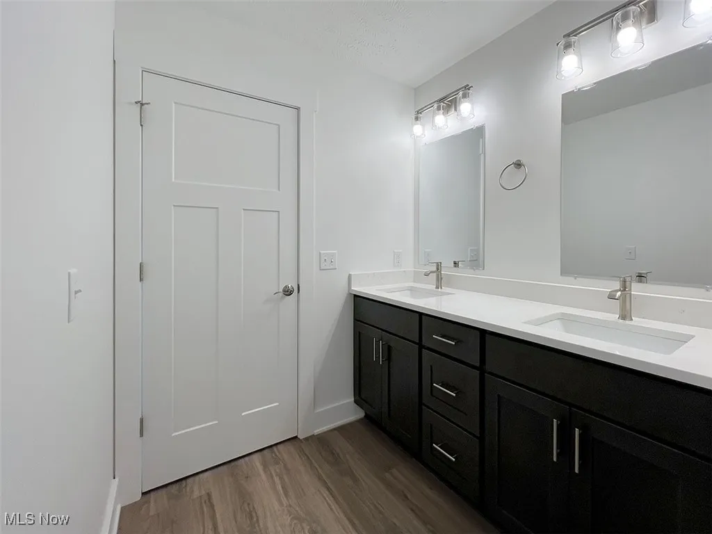 Master bathroom with double vanity and wood finished floors