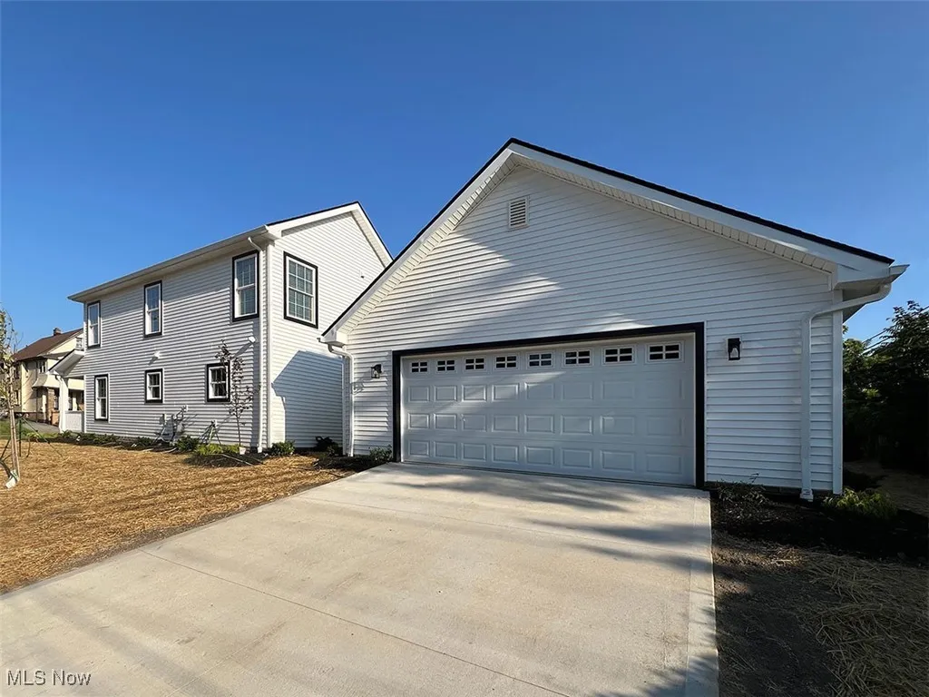 View of side of property with driveway and an attached garage