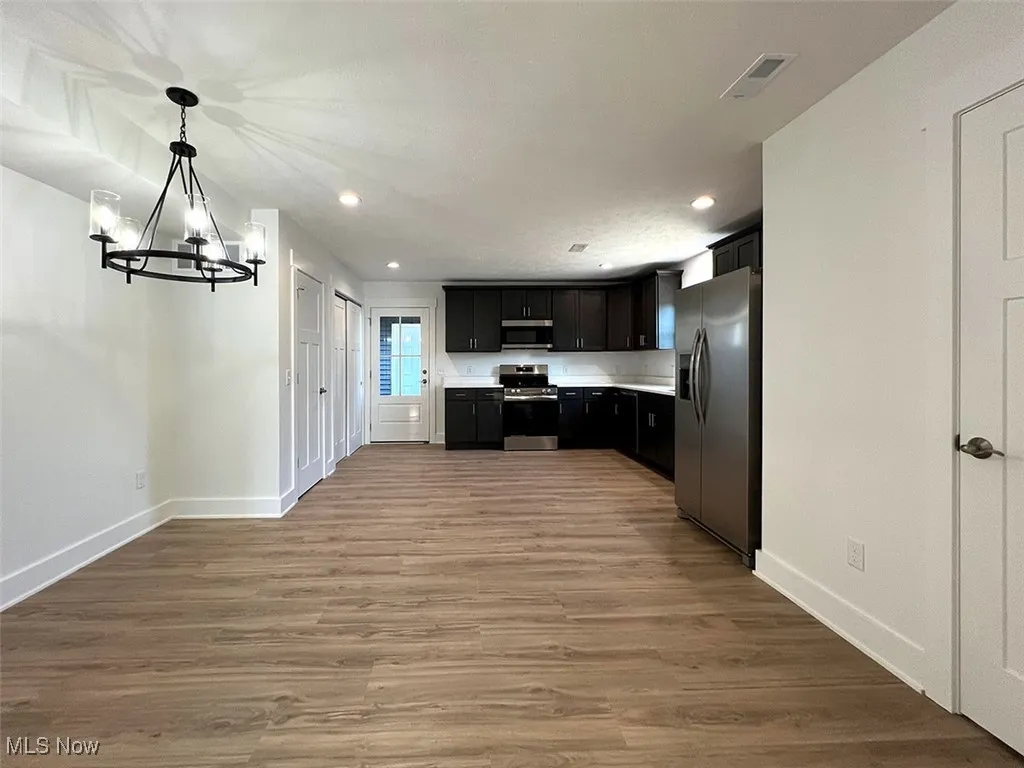 Dining area and kitchen featuring stainless steel appliances, recessed lighting, a chandelier, light countertops, and light wood-style flooring