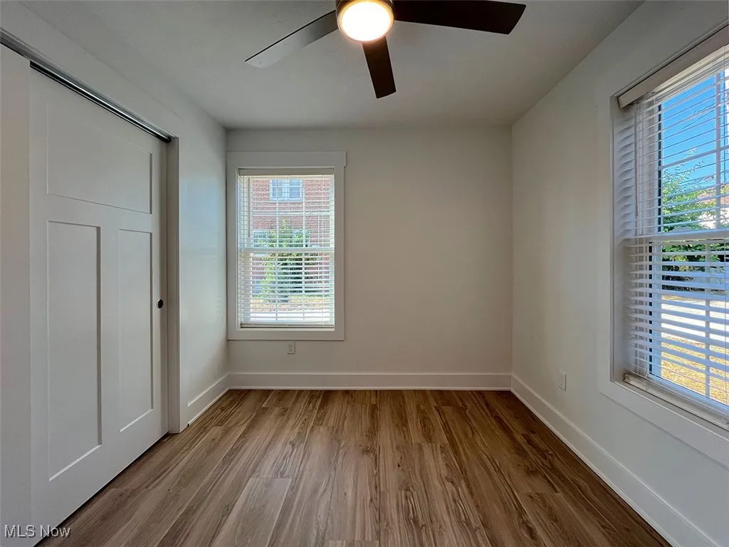 Unfurnished bedroom with wood finished floors and a ceiling fan