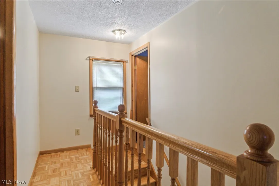 Hall featuring light parquet floors and a textured ceiling