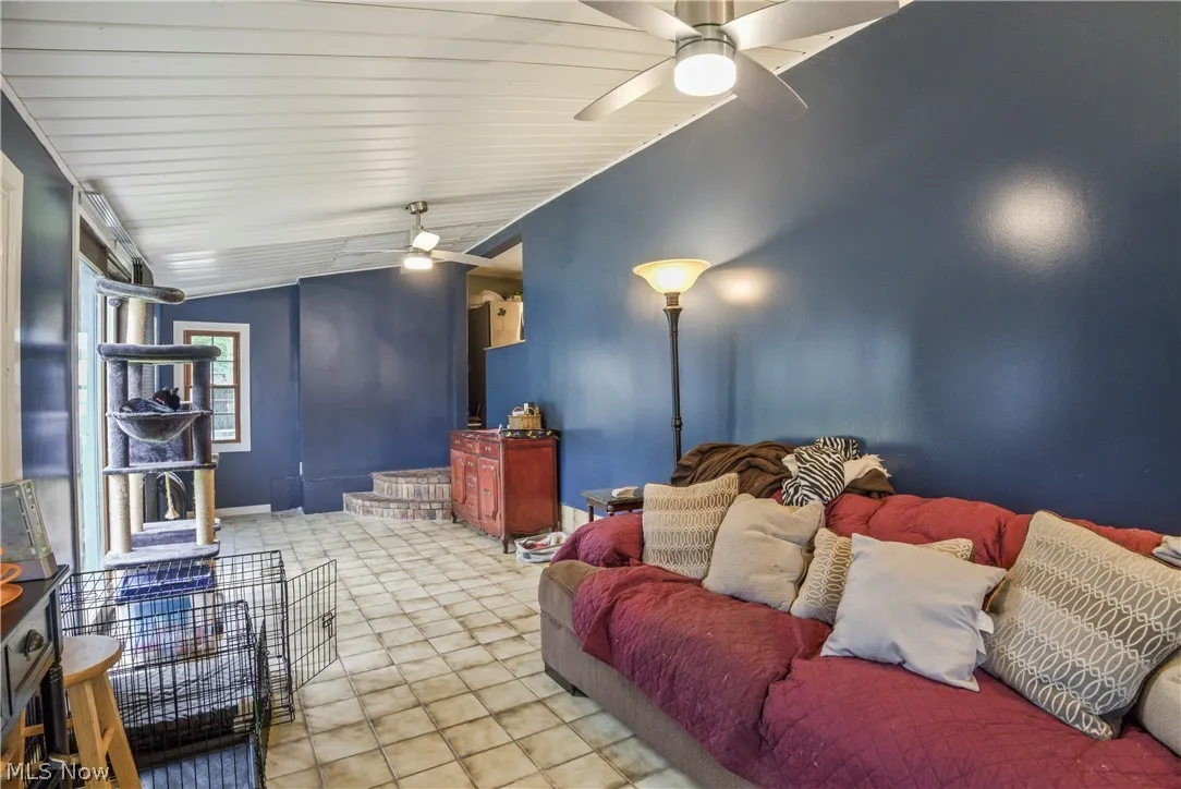 Cinema featuring tile flooring, lofted ceiling, and ceiling fan