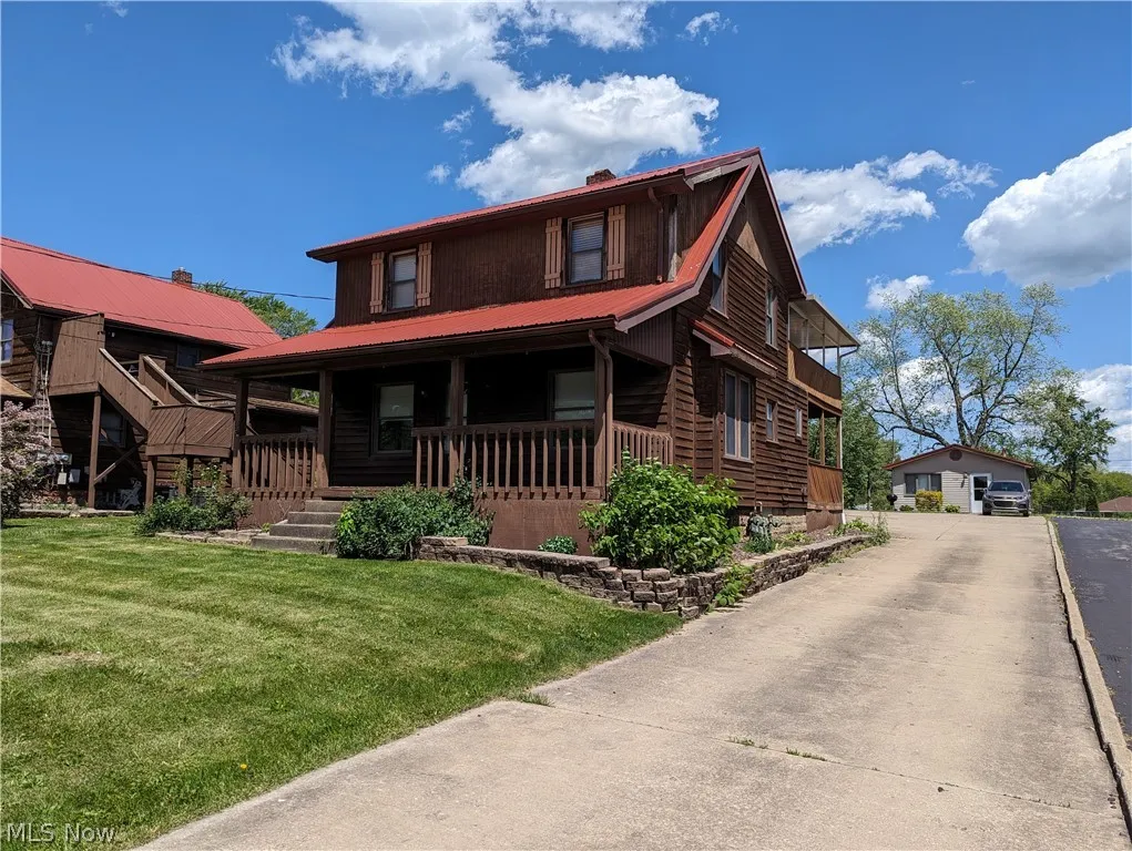 View of front of property with covered porch and a front yard