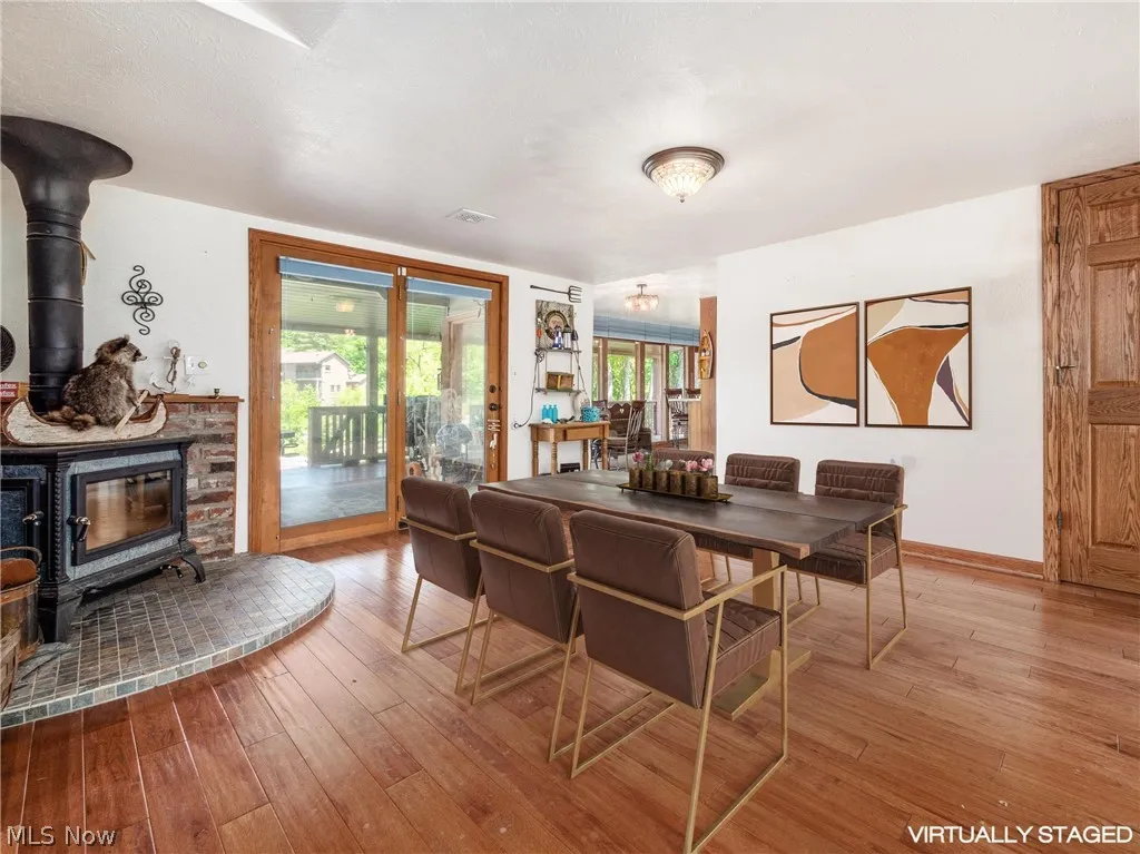 Dining room with hardwood / wood-style flooring and a wood stove