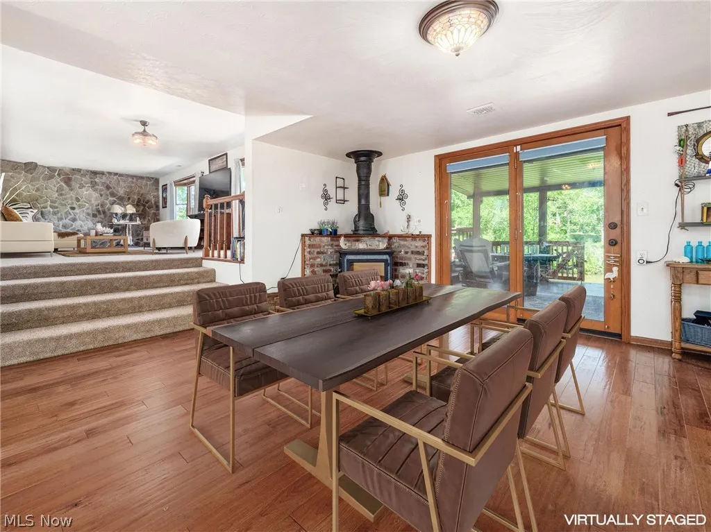 Dining room with a fireplace, hardwood / wood-style floors, and a wood stove