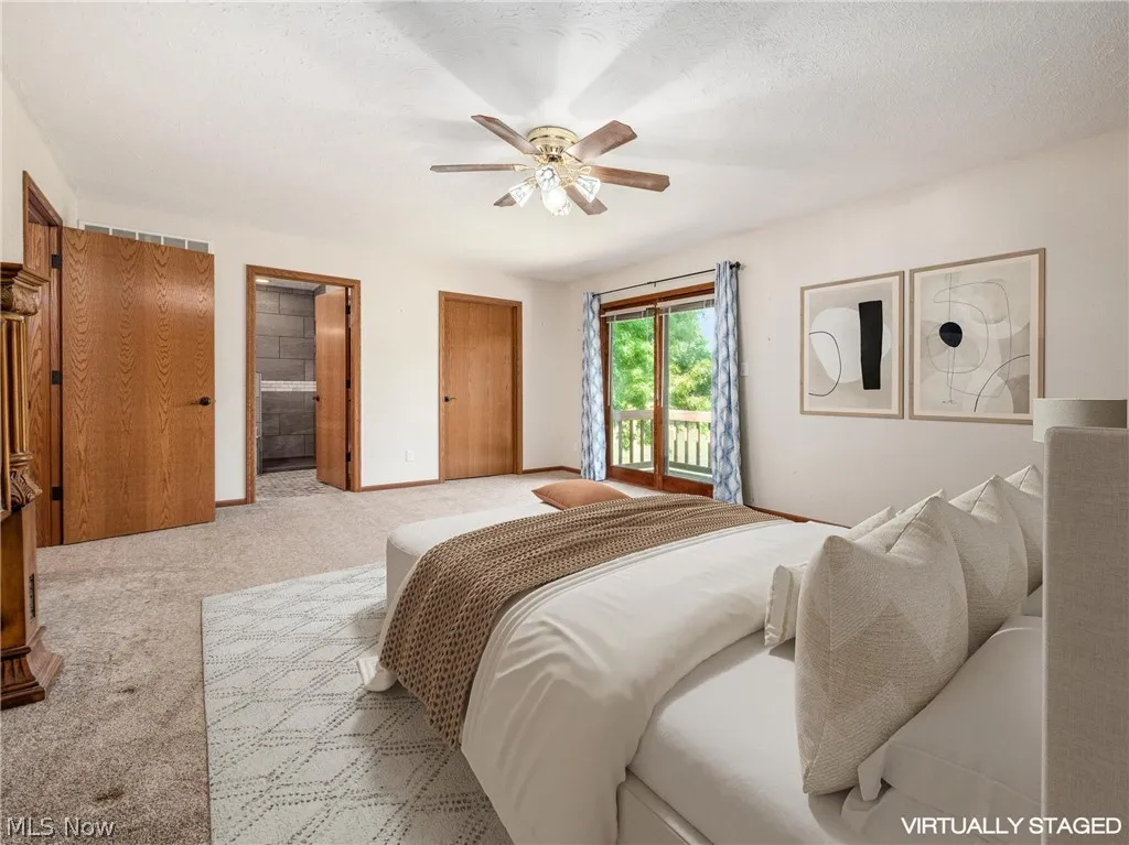 Carpeted bedroom featuring ensuite bathroom, ceiling fan, a textured ceiling, and access to outside