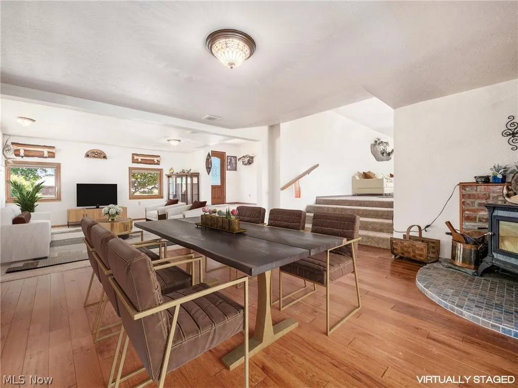 Dining room with a wood stove, light hardwood / wood-style floors, and a fireplace