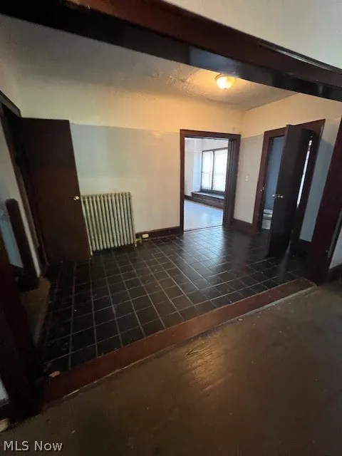 Tiled entrance foyer featuring radiator heating unit