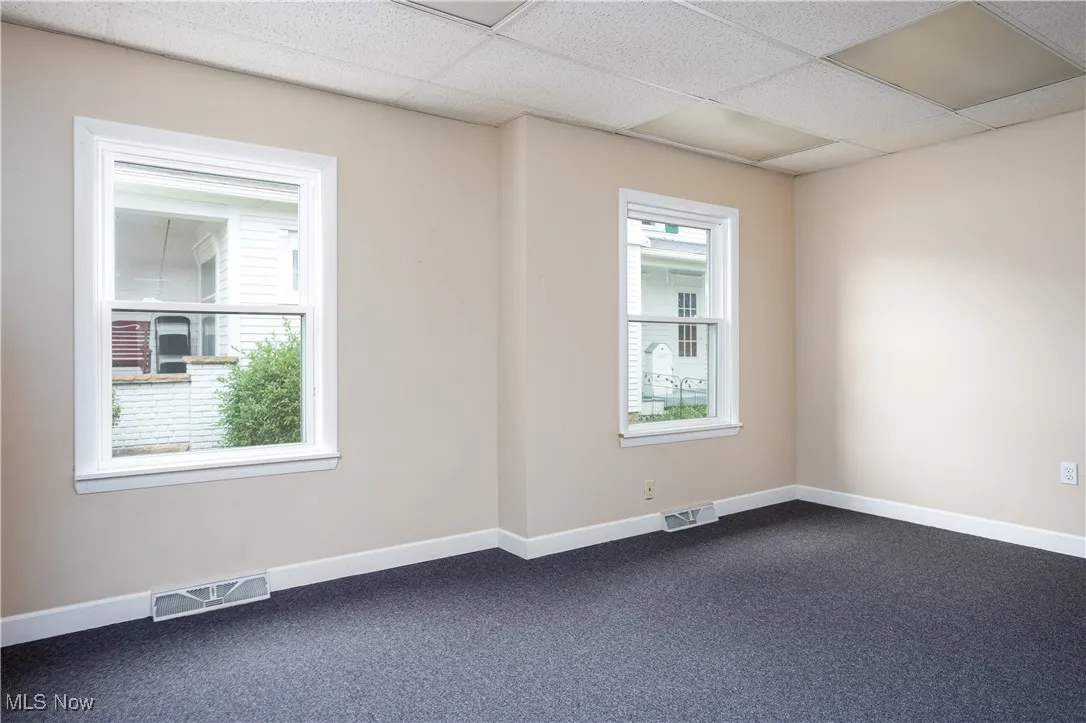 Carpeted spare room with a paneled ceiling