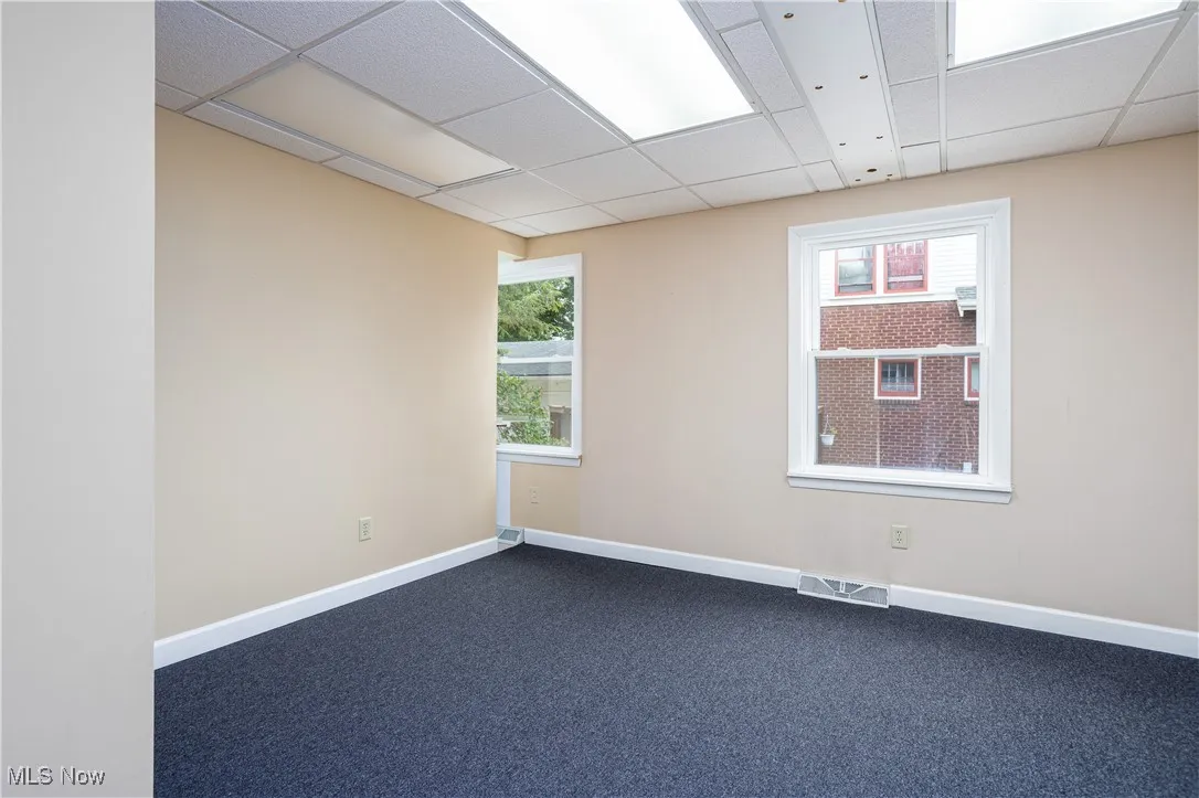 Carpeted spare room with a paneled ceiling