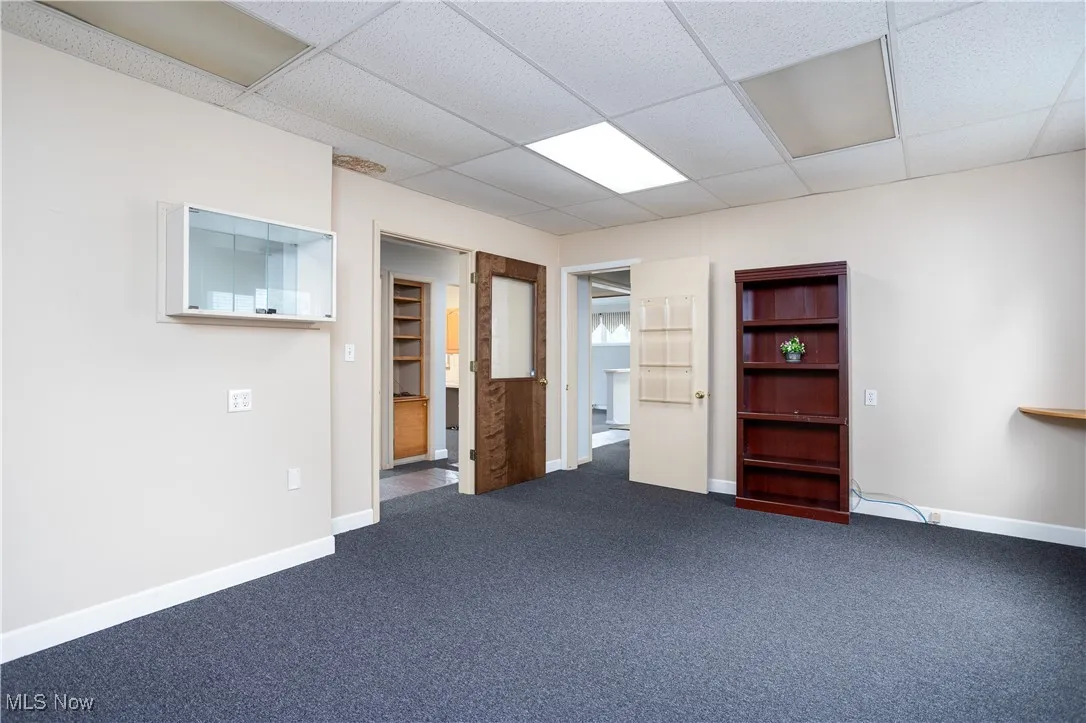Empty room with a drop ceiling and carpet
