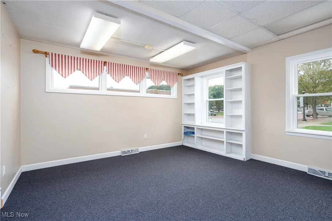 Unfurnished room featuring plenty of natural light and carpet flooring