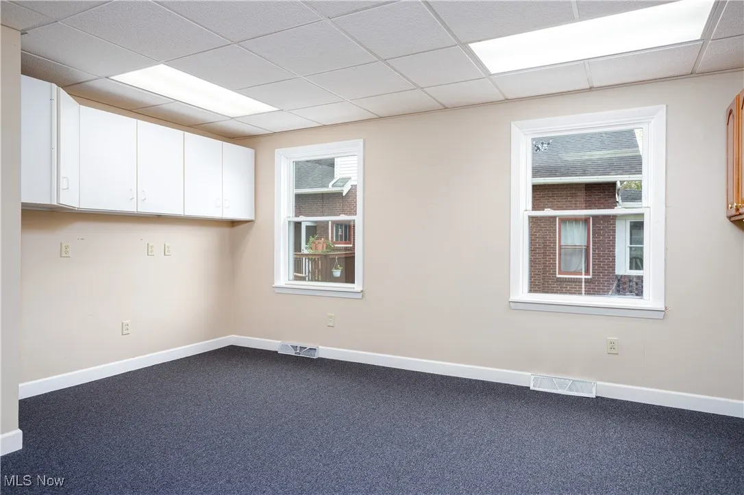 Unfurnished room with a drop ceiling and carpet