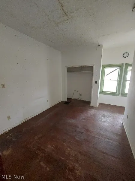 Unfurnished living room featuring dark hardwood / wood-style flooring