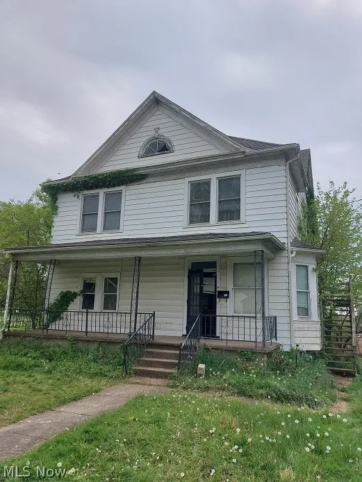 View of front of home featuring a front yard and covered porch
