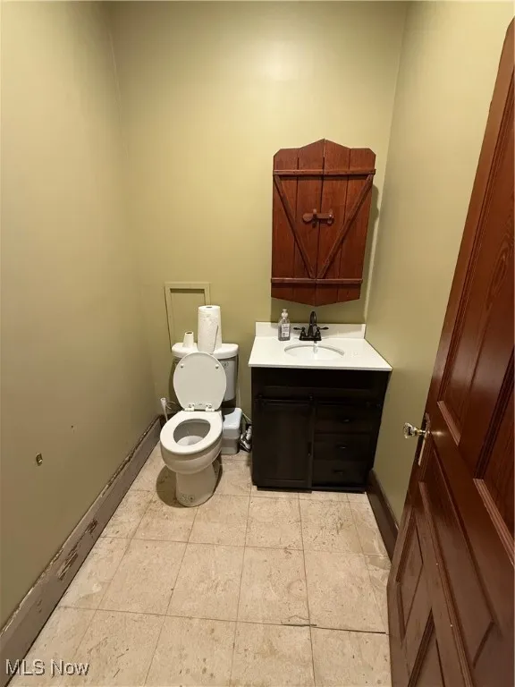 Half bathroom with vanity and tile patterned flooring