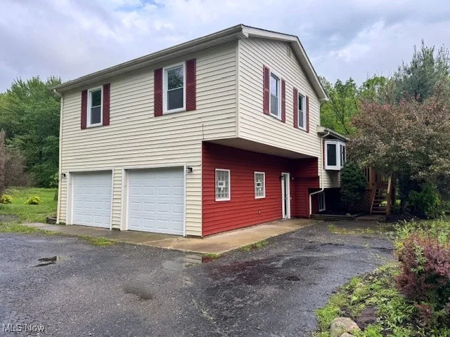 View of home's exterior featuring a garage and driveway