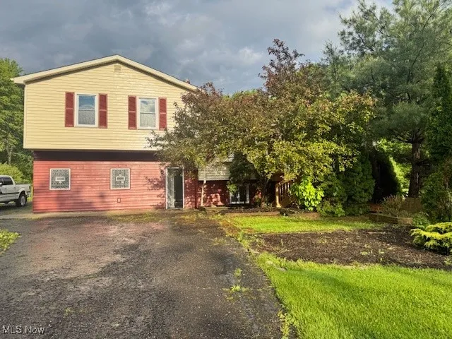 View of front of house featuring asphalt driveway