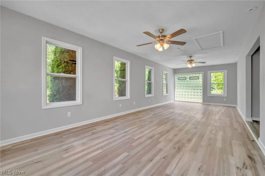 Empty room featuring ceiling fan and light laminate wood-style flooring