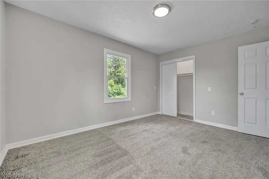 Unfurnished bedroom with carpet and a closet