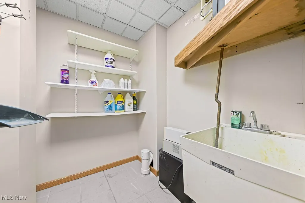 Laundry room featuring a drop ceiling and light tile patterned floors