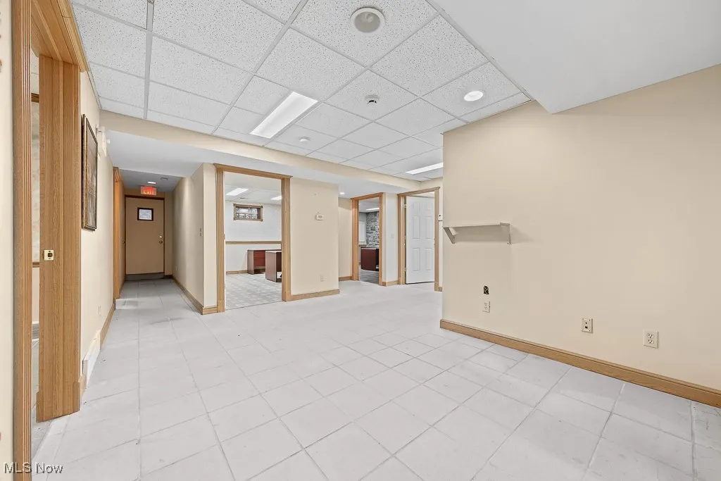Unfurnished room featuring a paneled ceiling and light tile patterned flooring