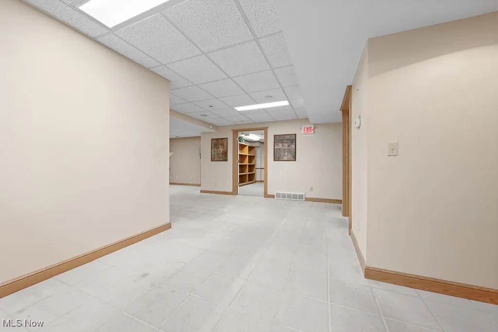 Spare room featuring baseboards and a paneled ceiling