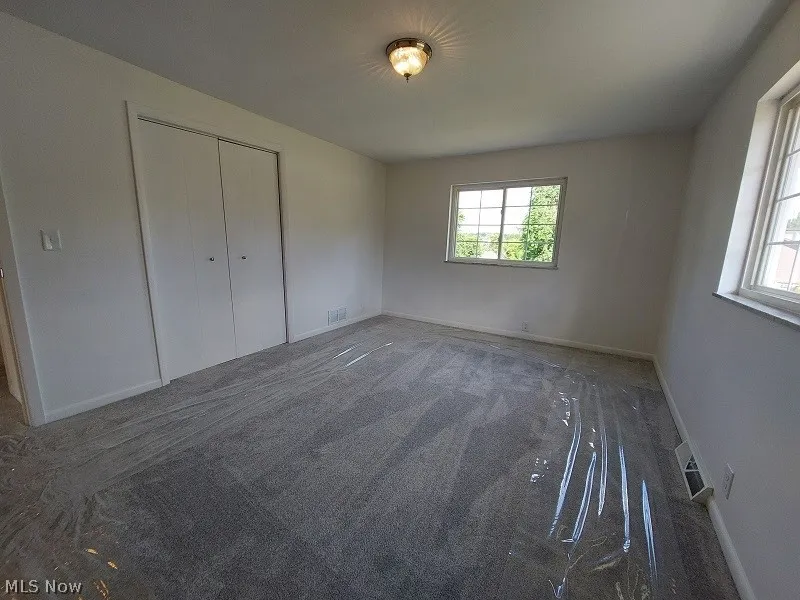 Unfurnished bedroom featuring carpet and a closet