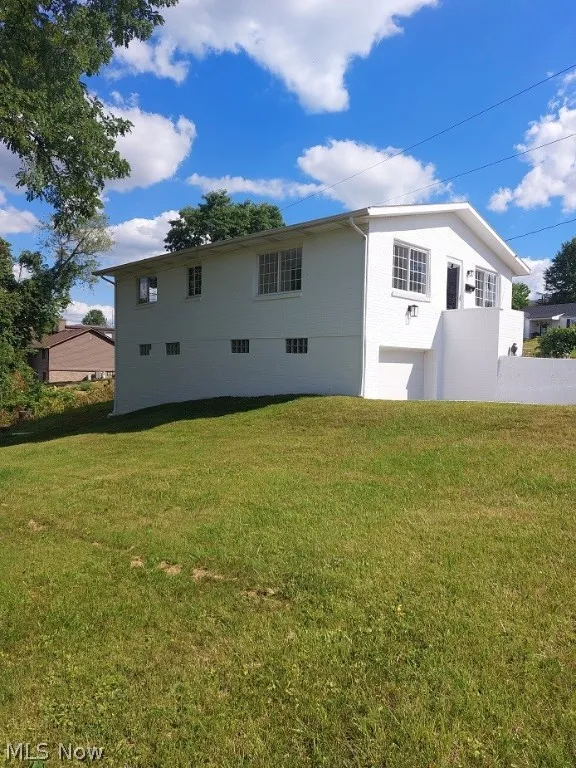 Rear view of property with a yard