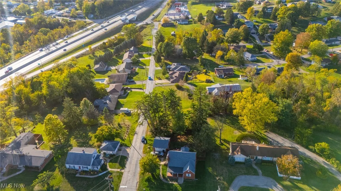 Aerial view of property and surrounding area with nearby suburban area