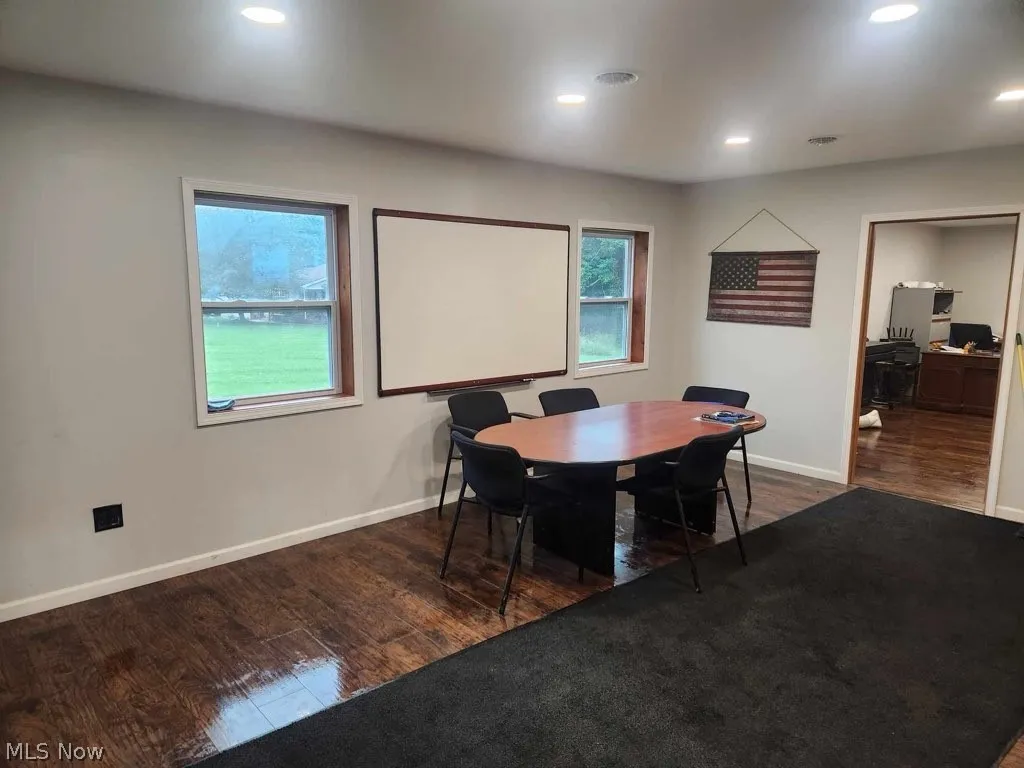Office space with dark hardwood / wood-style flooring