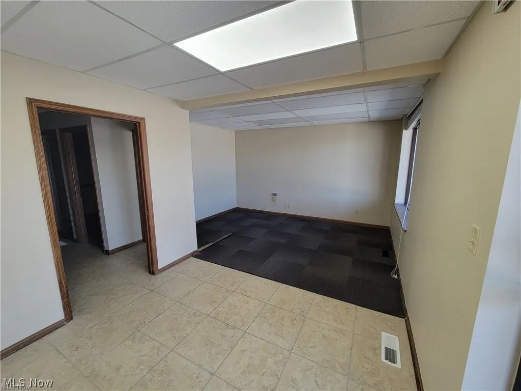 Spare room with tile patterned floors and a drop ceiling
