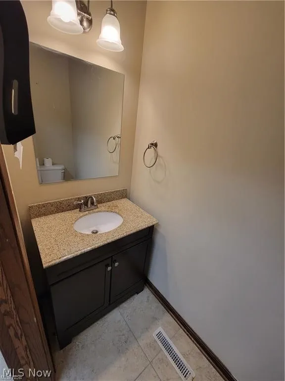 Bathroom featuring tile patterned flooring, toilet, and vanity