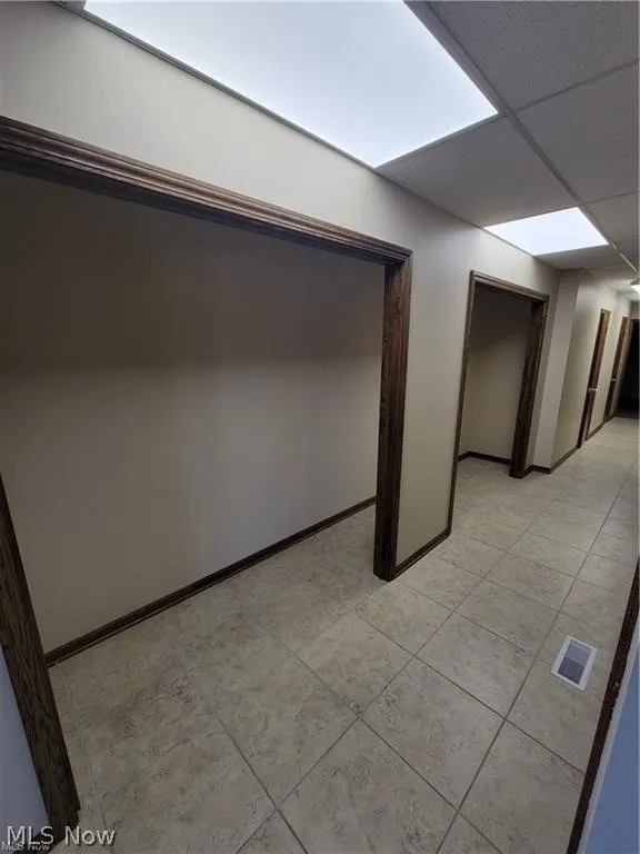 Tiled empty room with a drop ceiling