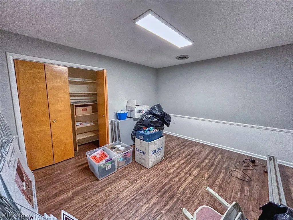 Unit B office with dark wood-type flooring, closet, and a textured ceiling