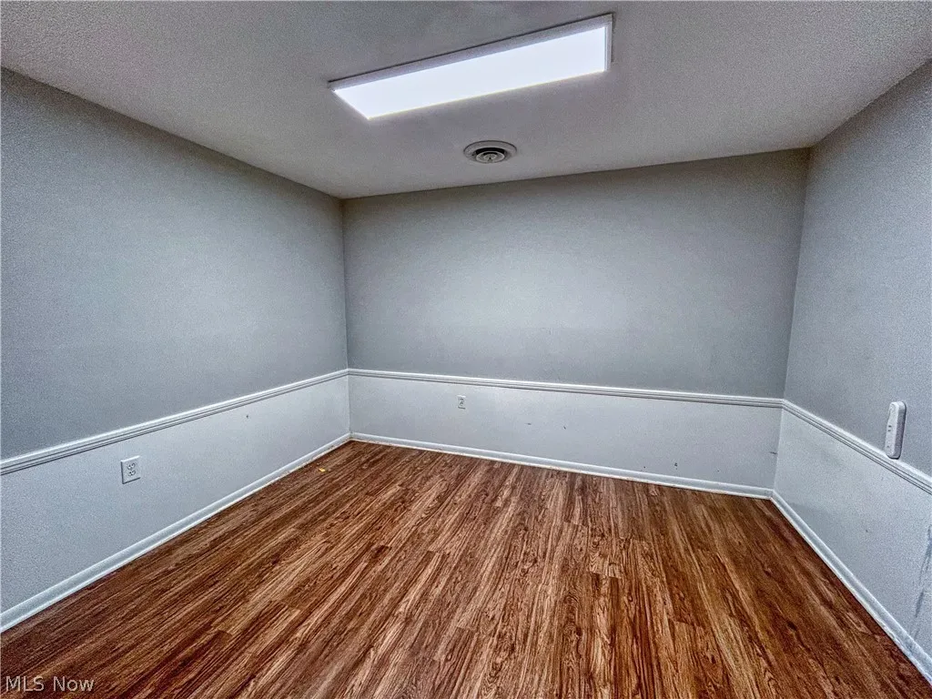 Unit B office featuring a textured ceiling and wood-type flooring
